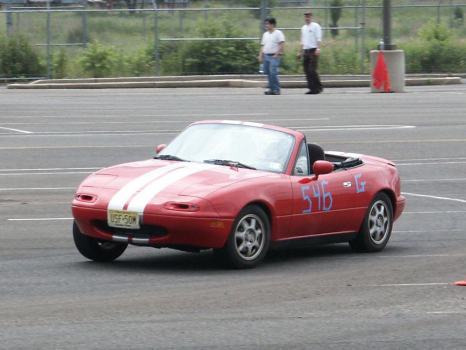 Red convertible with white stripes on hood, number 546 on door