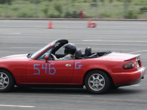 2001 Mercury Grand Marquis - A red convertible sports car with the number 546 taped to the driver's door is seen on a race track.