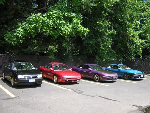 1995 Ford Probe - Several Ford Probes are parked in a lot, including a red one with front-end damage.