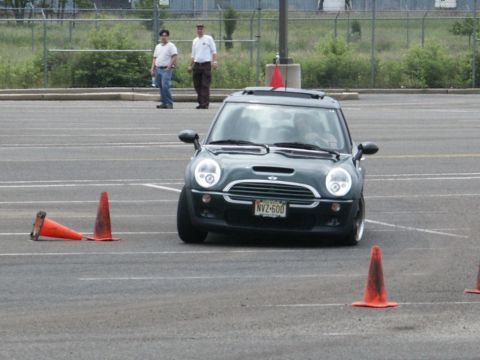 2001 Mercury Grand Marquis - A dark green Mini Cooper S is shown from the front, maneuvering through a course marked by orange traffic cones.