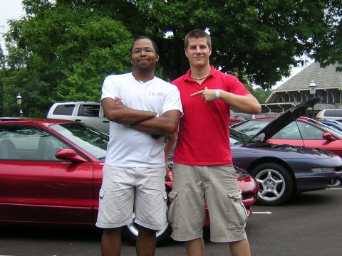 1995 Ford Probe - Two men pose with a red 1995 Ford Probe, which has its hood open, at an outdoor gathering.