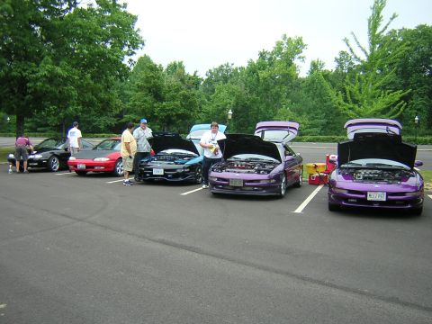 1995 Ford Probe - Several Ford Probes are gathered with their hoods open, attended by a few people.