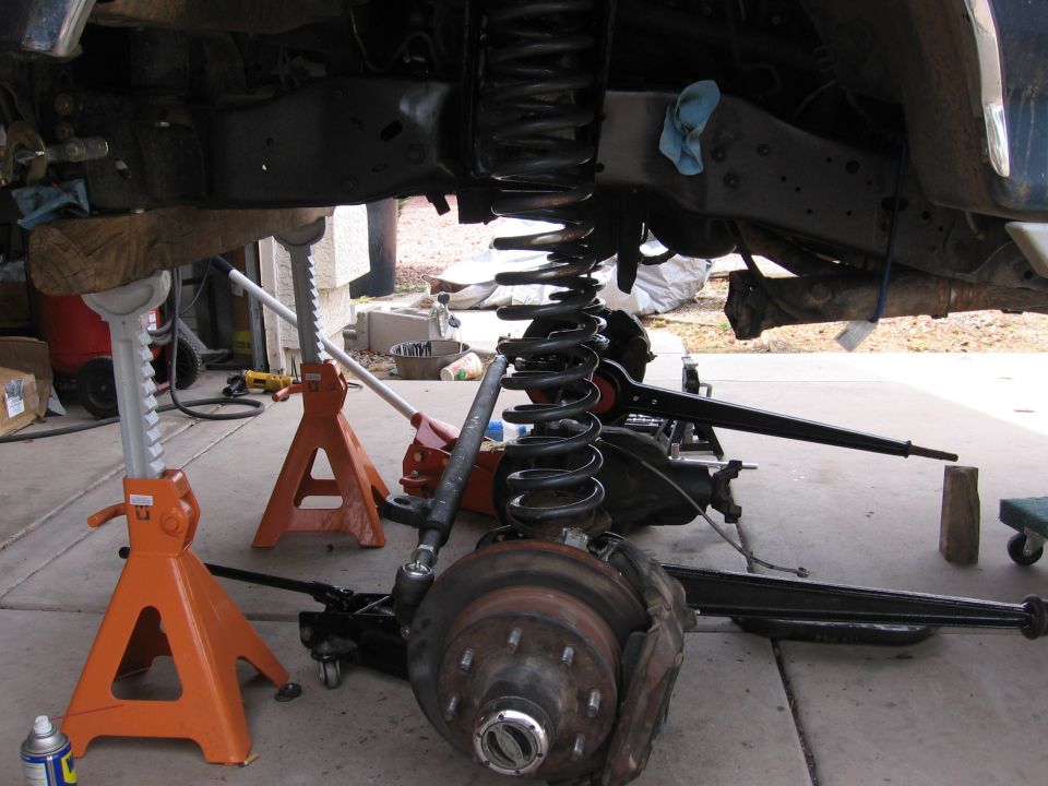 Vehicle suspension components, including coil springs and axle, supported by jack stands