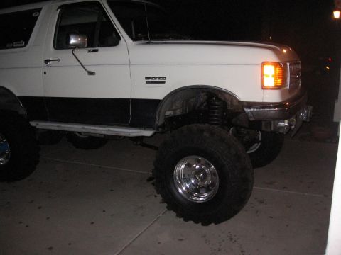 1990 Ford Bronco - This lifted Ford Bronco has a two-tone paint scheme and prominent off-road tires.