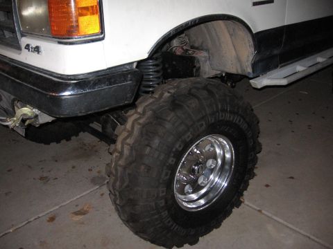1990 Ford Bronco - Close-up of a 1990 Ford Bronco's front fender and massive off-road tire.