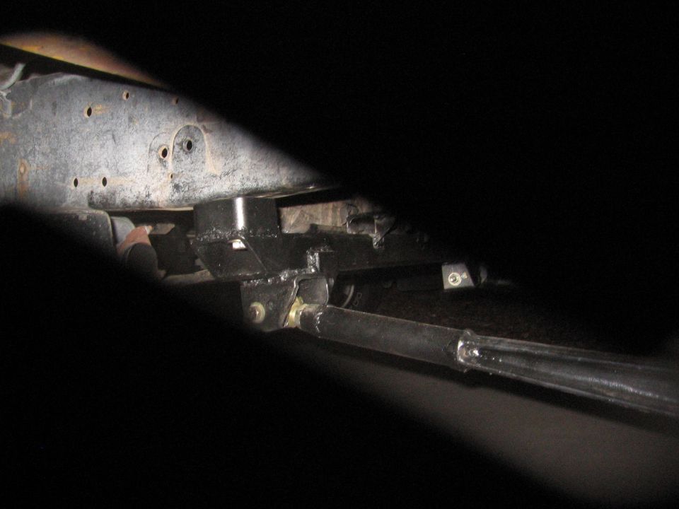 Vehicle frame with black suspension parts and a metal rod. Visible text: SUPERMOTORS.NET