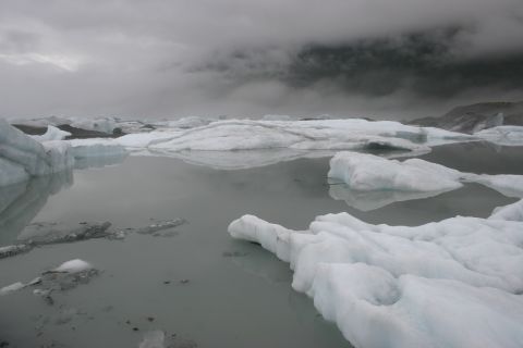 2003 Jeep TJ - Icebergs drift in glacial waters, reflecting the overcast sky.