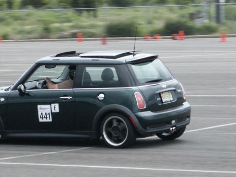 2001 Mercury Grand Marquis - Dark green Mini Cooper with racing numbers visible on the door, seen on a track.