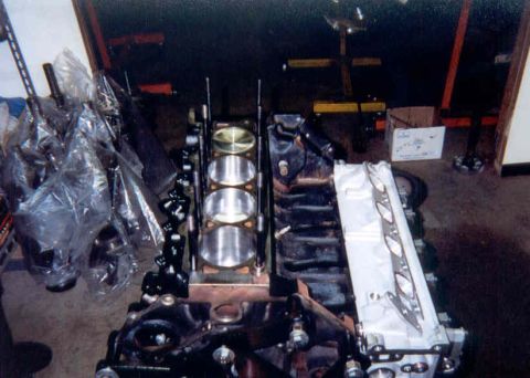 1992 Ford Crown Victoria - Overhead shot of a V8 short block mid-assembly on an engine stand, with one bank of pistons installed and head studs standing in the deck.…