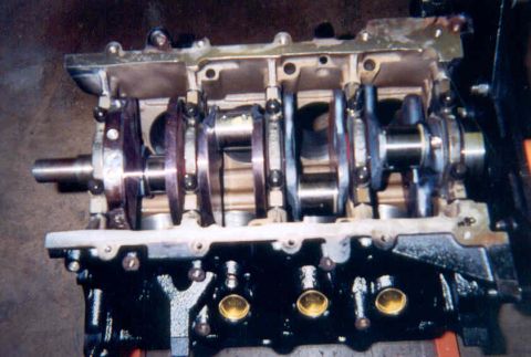 1992 Ford Crown Victoria - An engine block inverted on a stand during a rebuild, viewed from the bottom with the crankshaft laid in its main bearings, main caps not y…