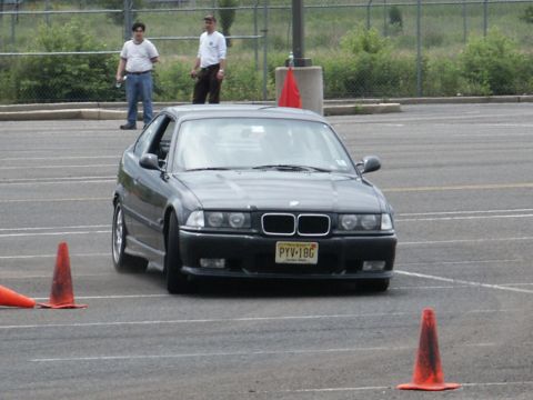 2001 Mercury Grand Marquis - A dark gray BMW E36 coupe navigates a course marked by orange cones.