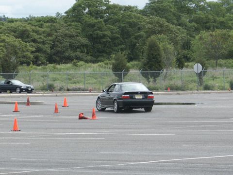2001 Mercury Grand Marquis - BMW 3 Series coupe navigates a course marked by traffic cones on a cloudy day.