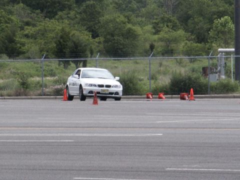 2001 Mercury Grand Marquis - A white sedan navigates a course marked by orange cones on a paved lot.