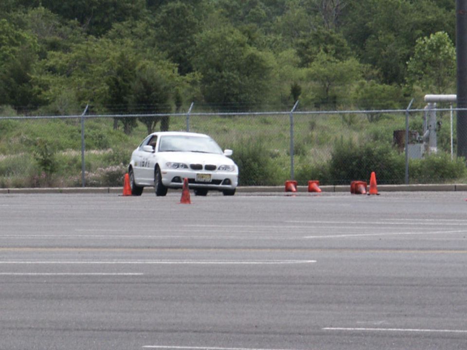 White sedan on a track with orange cones
