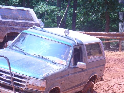 1996 Ford Bronco - Two Ford Broncos are stuck in the mud on a wooded trail.