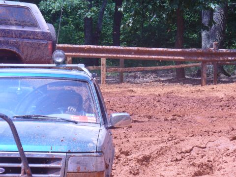 1996 Ford Bronco - A muddy 1996 Ford Bronco is seen off-road with another vehicle behind it.