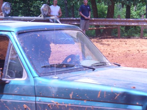 1996 Ford Bronco - Muddy 1996 Ford Bronco seen off-road with two men standing in the background.
