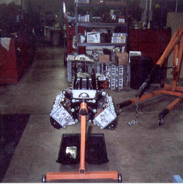 V8 short block with heads installed on an orange engine stand in a workshop