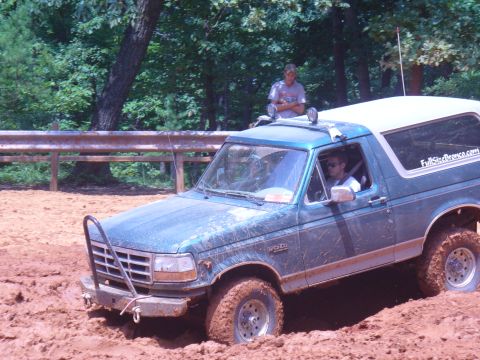 1996 Ford Bronco - A 1996 Ford Bronco is stuck in the mud, with a person standing on its roof.