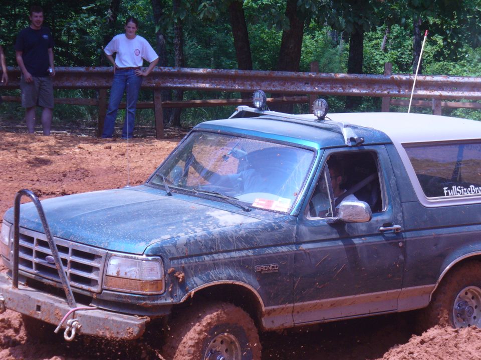 Green 1996 Ford Bronco stuck in mud, front bull bar, roof lights, off-road tires