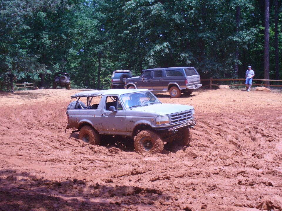 Silver convertible SUV stuck in mud, front grille visible