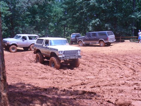 1996 Ford Bronco - Several Ford Broncos navigate a muddy off-road course.
