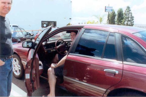 1992 Ford Crown Victoria - A dark red four-door sedan sits in a parking lot with the driver's door open, showing a burgundy cloth interior, column shifter and gray-fa…