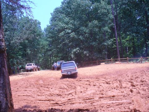 1996 Ford Bronco - Several Ford Broncos navigate a muddy off-road course on a sunny day.