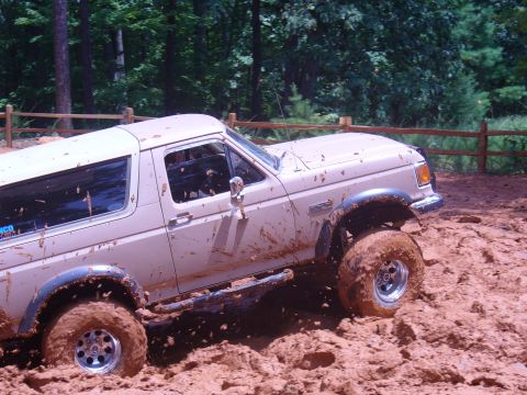 1996 Ford Bronco - This 1996 Ford Bronco is deep in the mud, showing off its off-road capabilities.