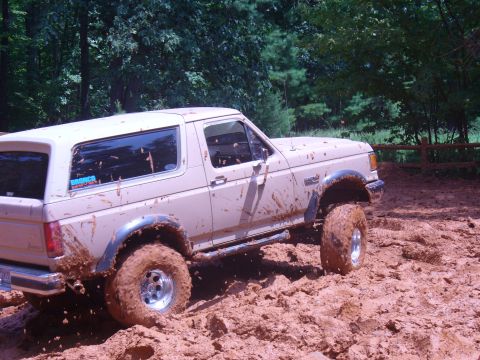 1996 Ford Bronco - 1996 Ford Bronco navigating a muddy off-road trail.