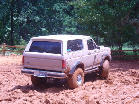 1996 Ford Bronco - This Ford Bronco is covered in mud as it navigates a dirt track.