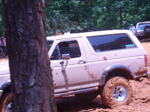 1996 Ford Bronco - This 1996 Ford Bronco is covered in mud after an off-road excursion, with another vehicle visible in the background.