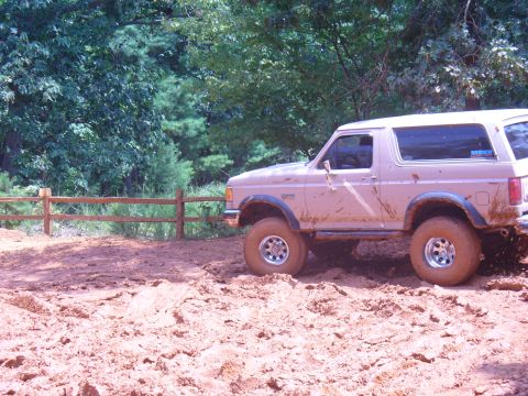 1996 Ford Bronco - A muddy 1996 Ford Bronco navigates a challenging off-road course.