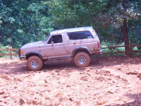 1996 Ford Bronco - This 1996 Ford Bronco navigates a muddy trail, showing off its off-road capabilities.