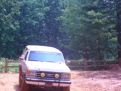 1996 Ford Bronco - White Ford Bronco with "FULLSIZEBRONCO.COM" sticker on windshield, driving off-road.