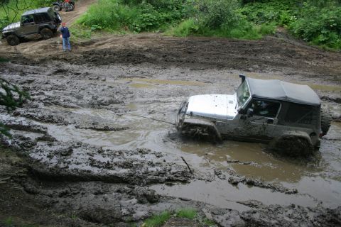 2003 Jeep TJ - Two Jeeps and ATVs navigate a muddy off-road course.