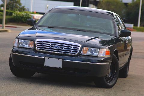 1998 Ford Crown Victoria - Front view of a dark 1998 Ford Crown Victoria, its distinctive grille and headlights.