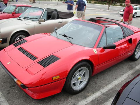 1998 Ford Crown Victoria - red Ferrari 308/328-style targa with side intake louvers and silver five-spoke wheels in a parking lot.