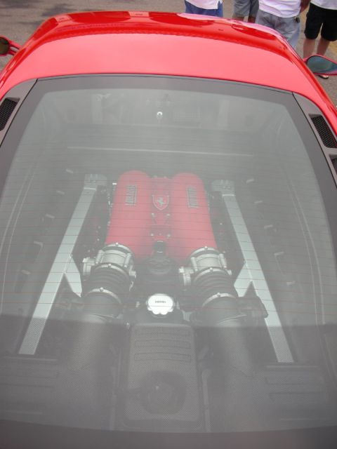 1998 Ford Crown Victoria - red-finished V8 with twin intake plenums seen through the rear glass engine cover of a sports car.