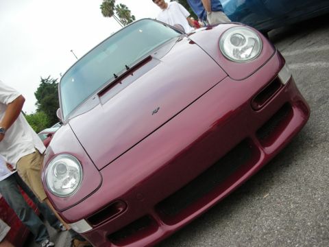1998 Ford Crown Victoria - Low-angle front view of a maroon Porsche 911 with round headlights and the Porsche crest on the hood.