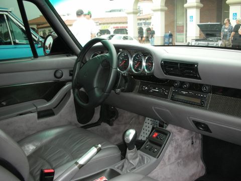 1998 Ford Crown Victoria - Gray leather interior of a Porsche 911 showing the gauges, manual shifter and carbon-fiber dash trim.