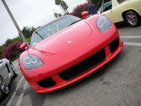 1998 Ford Crown Victoria - Head-on view of a red Porsche Carrera GT showing its low nose, twin round headlights and Porsche crest.
