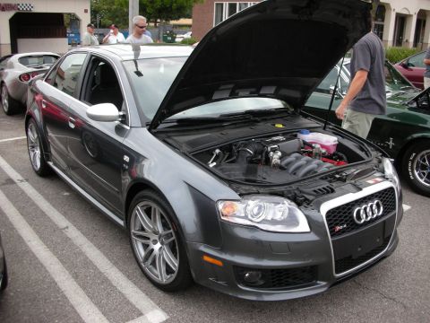 1998 Ford Crown Victoria - gray Audi RS4 sedan sits with its hood open and engine exposed, parked among other show cars on a paved lot.