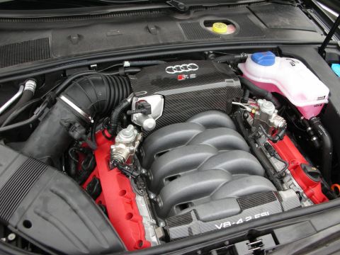 1998 Ford Crown Victoria - detailed Audi RS V8 4.2 FSI engine with carbon-fiber intake covers and a pink-fluid reservoir fills the open engine bay.