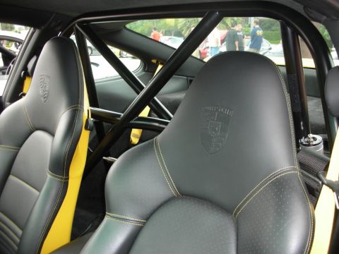 1998 Ford Crown Victoria - interior of a Porsche shows black leather bucket seats with Porsche crests, a welded roll cage, and yellow side accents.