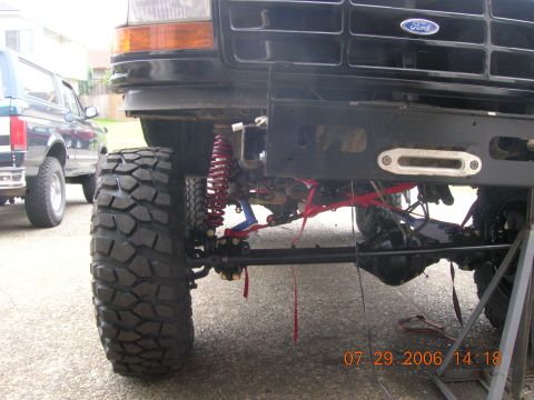 1996 Ford Bronco - Front view of a modified black Ford Bronco with off-road tires and suspension components visible.