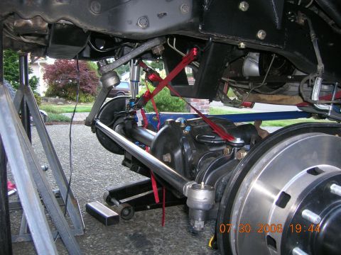1996 Ford Bronco - Undercarriage view of a vehicle's suspension system, showing the front axle and steering components.