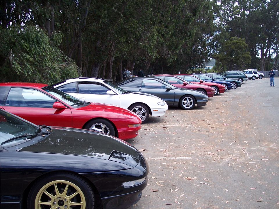 Several Ford Probe cars parked in a row, black, red, white, and gray models visible