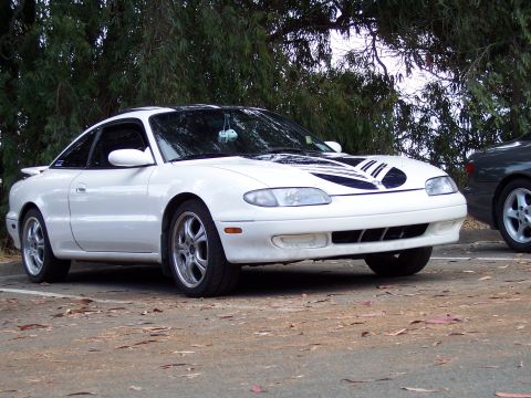 1995 Ford Probe - A white Mazda MX-6 is parked outdoors, with another car visible to the right.