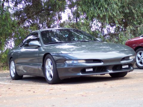 1995 Ford Probe - A gray 1995 Ford Probe is parked outdoors, with another vehicle visible to the right.